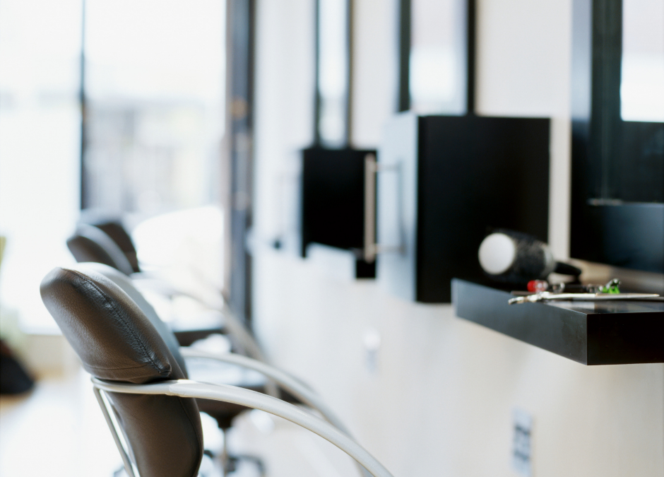 Elegant salon interior with a "For Sale" sign, showcasing the partnership with Meritus Group Business Brokerage.