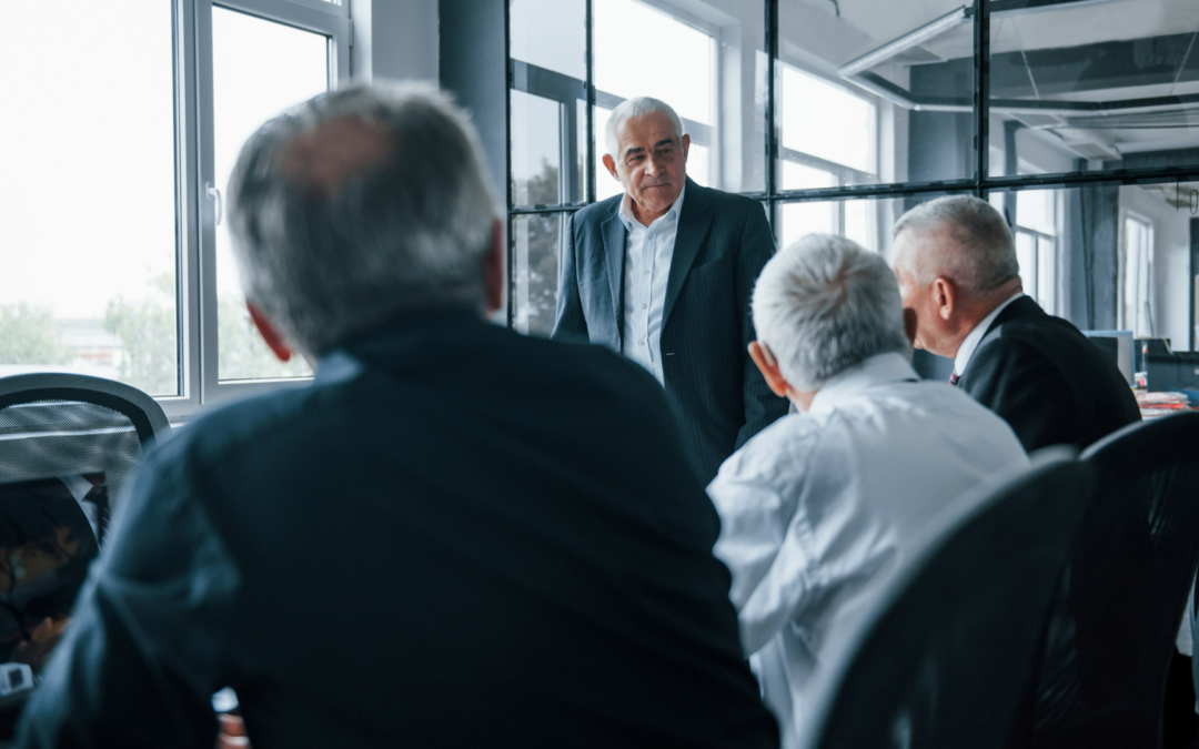 Senior business leader discussing strategic sale with potential buyers in a meeting